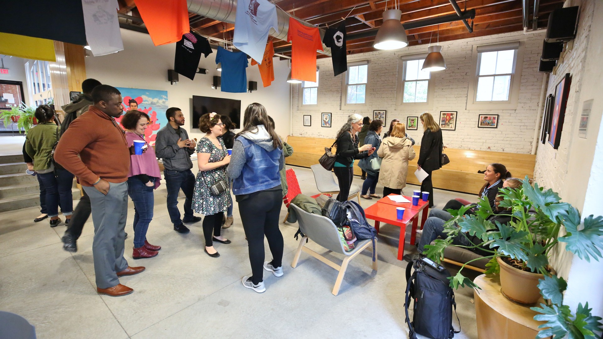 People who showed up for art opening talking to each other.