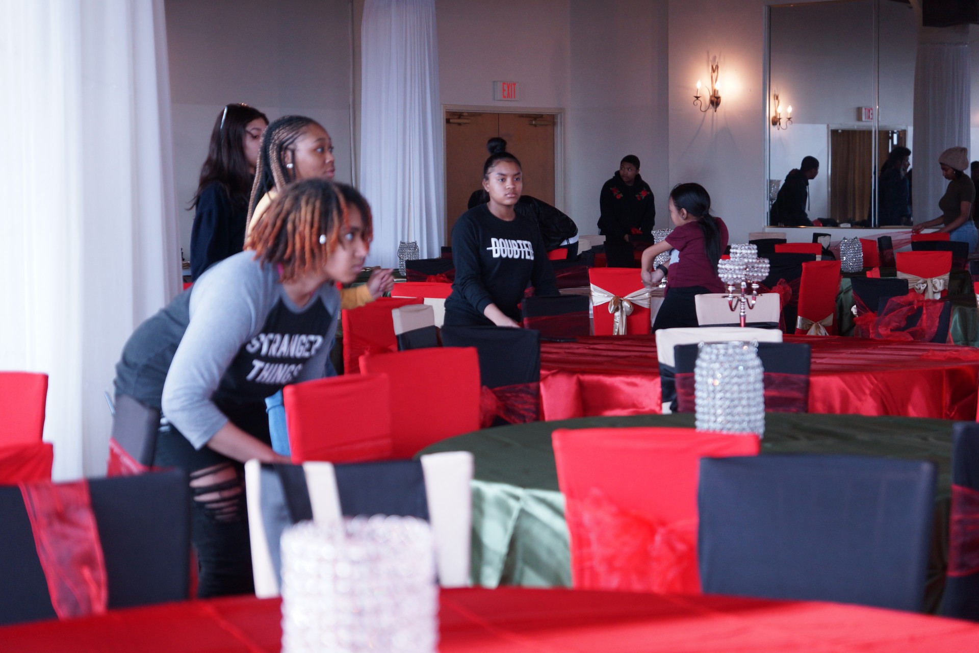 Volunteers Decorating chair covers with bows.