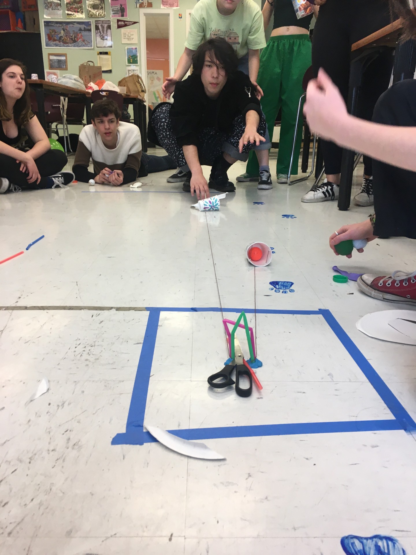 Team 1 performing their ball transporting system. They had to operate under a 6 minute time constraint and could not communicate verbally during their build time and had to stand behind the line to present their pulley solution.